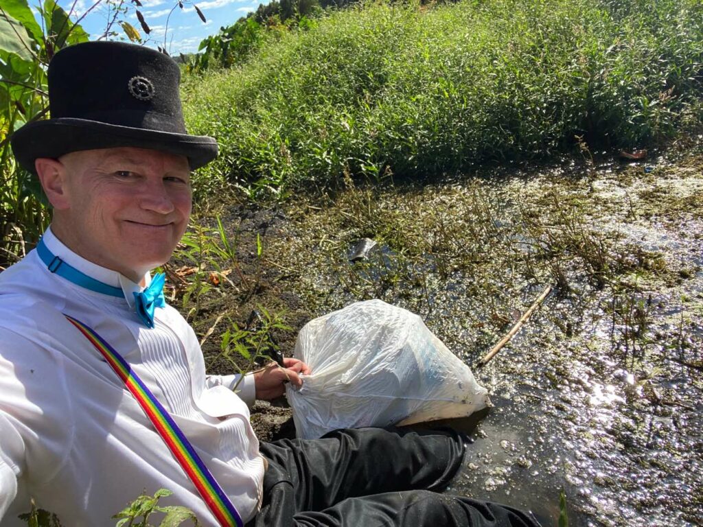 James Carvin in a pond cleaning up trash